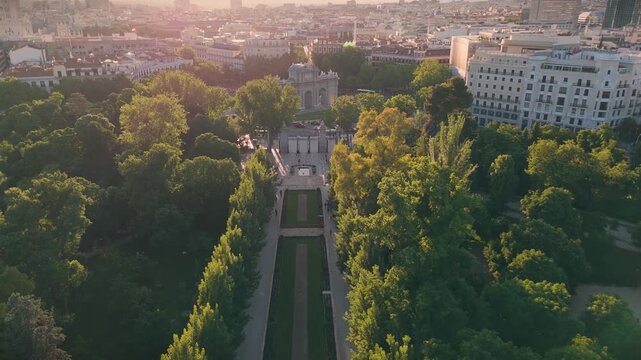 Aerial tracking shot from inside El Retiro Park looking towards the historic Puerta de Alcala monument