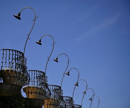 Traditional handcrafted wrought iron street light fixtures and balcony railing in Savoca Sicily, Italy.