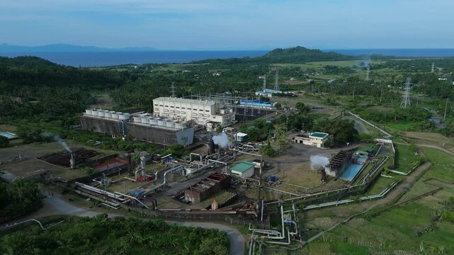 Aerial view of geothermal power plant surrounded by hills and ocean in Tabaco City, Philippines.Ideal for industrial and business concepts.