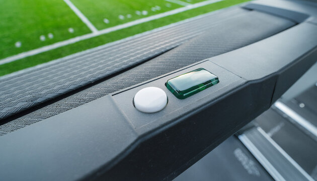 A treadmill&rsquo;s green switch stares back, a quiet portal at the edge of the indoor field
