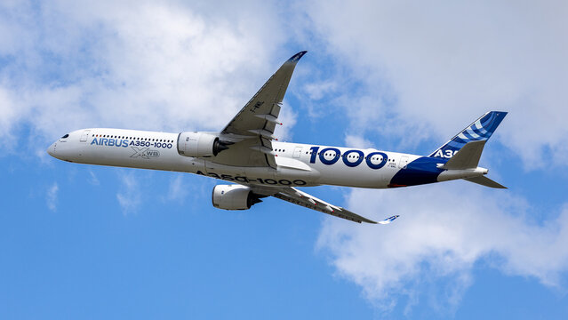Ein Airbus A350-1000 XWB in der Werks-Bemalung von Airbus (Kennzeichen F-WMIL) beim Flugvorfuehrung vor bewolktem Himmel.