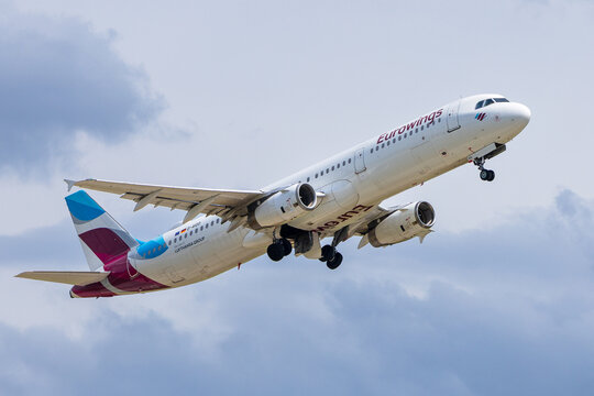 Ein Airbus A321 der Eurowings (Lufthansa Group) steigt kurz nach dem Abheben steil in den bewoelkten Himmel. 
