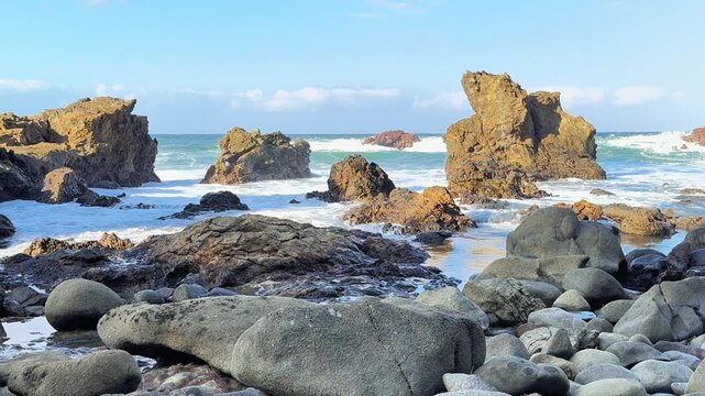 Rocky Shoreline Serenity: The rugged beauty of a rocky shoreline meets the gentle ebb and flow of the ocean under a clear blue sky, evoking a sense of peace and natural wonder.