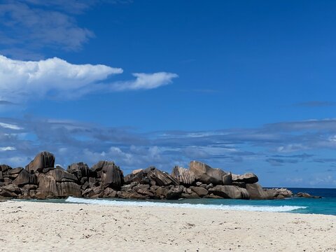 The beautiful Grand Ance Beach on La Digue Island in the Seychelles. Turquoise sea, waves, huge cliffs, white sand