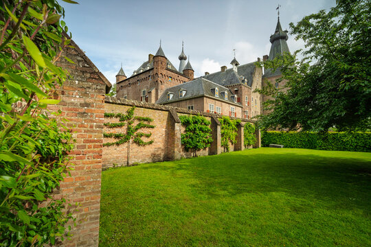 Sunlight dapples ancient brick walls and lush green lawns.
