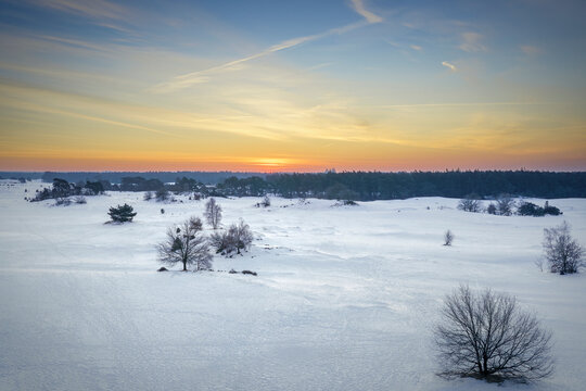 Golden sunset paints the snow-covered landscape with serene hues.