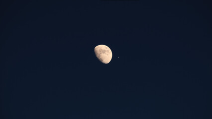 Waxing gibbous Moon and planet Venus on a daylight blue sky. © astrosystem