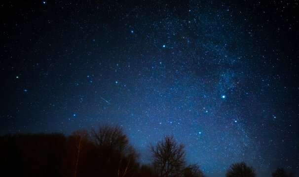 Milky way stars and rural countryside silhouettes.