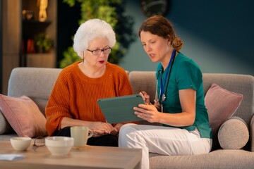 Healthcare professional discussing treatment and care plan with elderly patient during home...