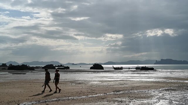 Travelers walking on Tubkaek Beach shoreline