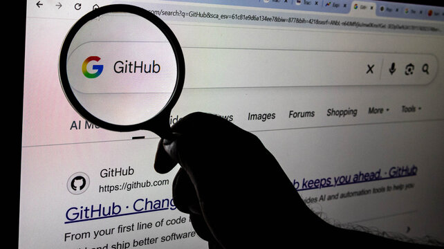 A magnifying glass held over a computer screen showing a google search result for github, symbolizing research, investigation, and digital exploration