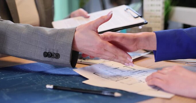 Female manager and architect designer shake hands in corporate office. Businesswoman makes deal with contractor in agency boardroom slow motion