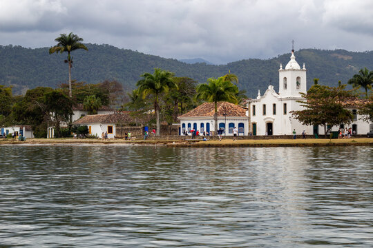 Historic white colonial church Santa Rita on the waterfront of Paraty with mountains in the background