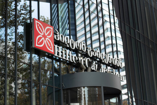 Tbilisi, Georgia - January 21, 2026: Photo of logo of Hilton Garden Inn hotel with leaf on red square on glass wall. Concept of tourism, check in, guest, travel, rent apartment, vacation
