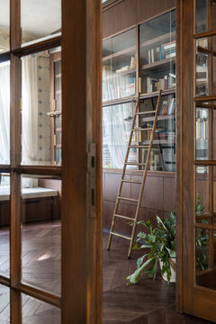 Bookshelf with ladder in warm interior
