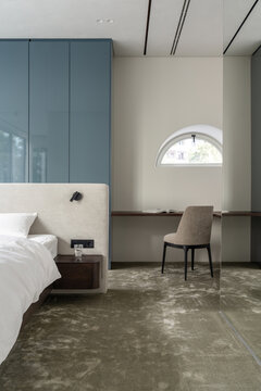 Minimal bedroom with blue wardrobe and workspace
