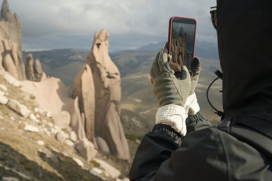 Tourist Takes Picture of Rock Formations in the Mountains