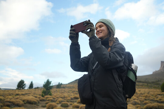 Hiking Person Using Smartphone to Take a Picture in the Mountains