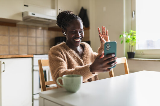 Happy African Woman Waving Hello During Video Call on Smartphone