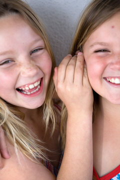 Two Girls Laughing While Telling Secret