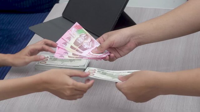 Currency Exchange Transaction of Indonesian Rupiah Banknotes for US Dollar Cash.