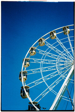 a ferris wheel arc cutting into the sky, 35mm film