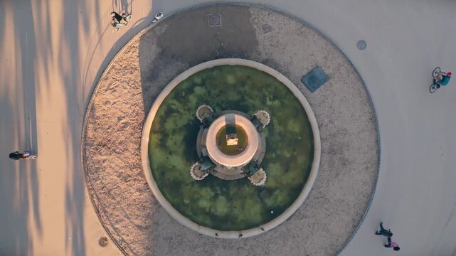 Top down aerial view of a stone fountain in El Retiro Park during golden hour