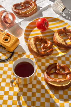 Freshly Baked Pretzels on a Table With a Cup of Tea and a Camera