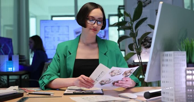 Architect reviews complex construction sketches. Architectural designer shows confident thumbs-up gesture and smiles warmly. Slow motion