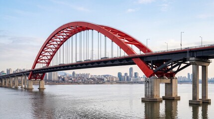 Fototapeta premium Large red arch bridge over river with city skyline