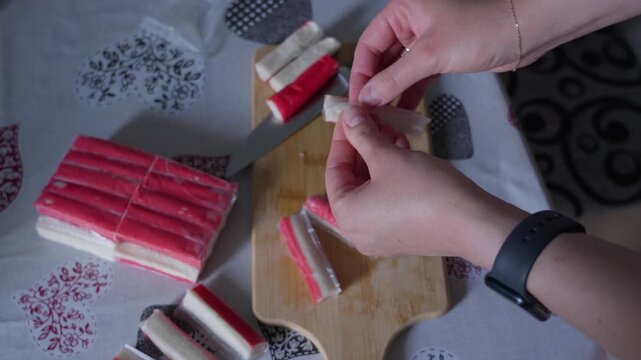 Hands Unwrapping Crab Sticks for Home Meal Preparation