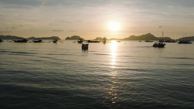 Sunset over the boats and small islands in Corong Corong Beach. El Nido, Palawan. Philippines.