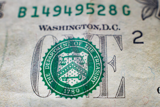 Macro shot of the US department of the treasury green seal on a one dollar bill