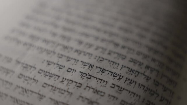Close-up of Hebrew text on an open Bible book page. Soft focus highlights the words' texture and depth. Jewish Torah study. Ideal for religious, cultural, or scholarly visual projects
