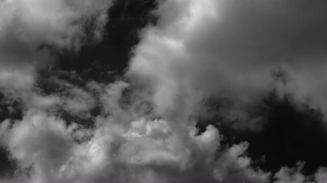 Time-lapse of floating white clouds creates a striking visual contrast against black.