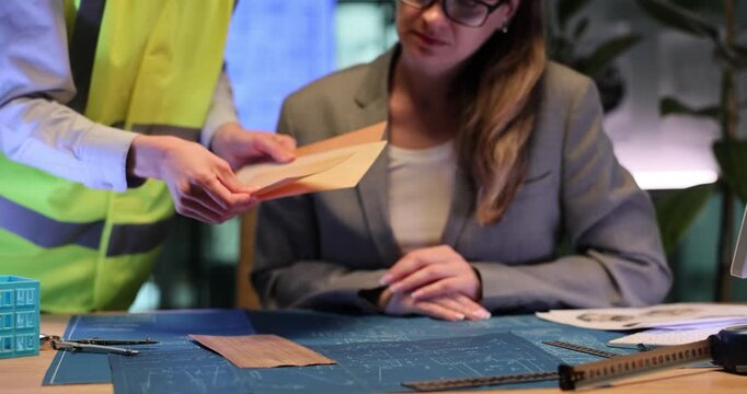 Builder shows elegant floor finishing colors to director. Construction worker discusses interior decoration ideas with businesswoman. Slow motion
