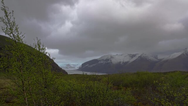 Explore Jokulsarlon glacier with dark skies and moody fg shrubs
