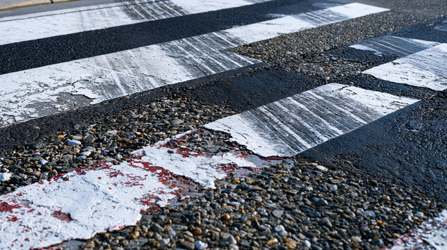 Crosswalk parallel stripe pattern worn asphalt markings extreme close perspective, thermoplastic paint edges lifting from road surface, aggregate texture visible through faded sections, tyre track m