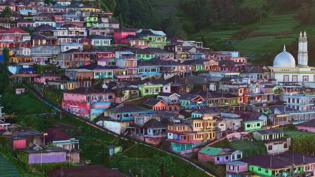 Picturesque countryside village on a lush mountain slope with vibrant homes, and scenic sunrise atmosphere. Nepal Van Java, Indonesia.