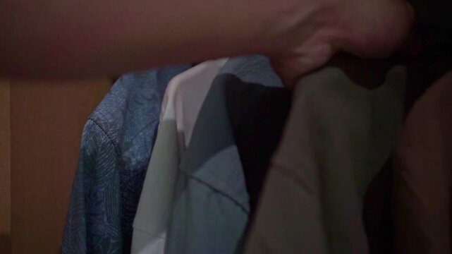 footage of hanging clothes in a closet, ideal for concepts of organization, housekeeping, wardrobe care, and minimalist living.