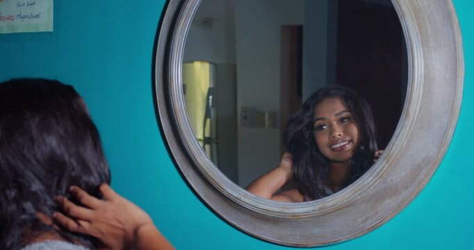 Playful East Indian girl jumping onto a soft, plush bed in colorful silk pajamas, full shot, cheerful indoor lifestyle video.