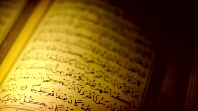 Golden glowing light shining on the text of the Holy Quran