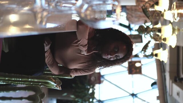 Confident successful young African American woman relaxing at the bar counter of a restaurant