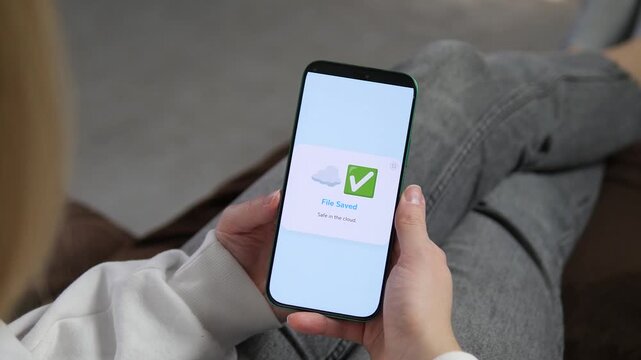 Backing up photos and videos to the cloud. Hands tap Upload to Cloud and receive a File Saved confirmation. Perfect for data security, digital storage, and mobile backup solutions.