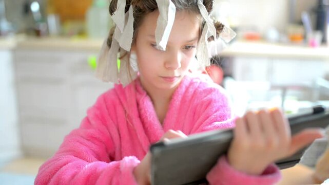 Small beautiful girl plays on tablet computer