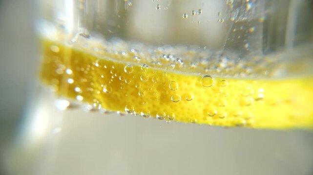 Macro of air bubbles on a lemon in a glass of water