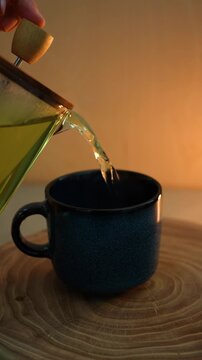 Pouring tea into a cup, a cozy evening atmosphere