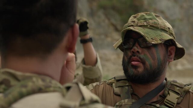 Special forces soldiers with camouflage face paint are strategizing during a covert military operation, discussing tactical plans for their critical field mission.