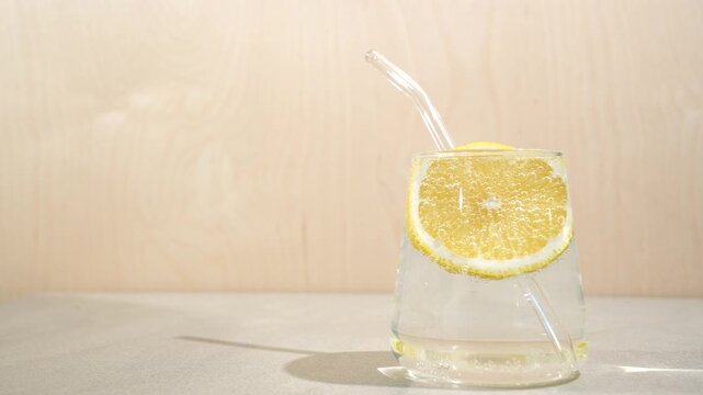 Lemon water in a glass on the table in the sunlight, a morning water intake for good health