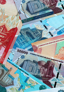 Uzbekistani som money banknotes pile on table. Uzbekistan bills of UZS currency close up